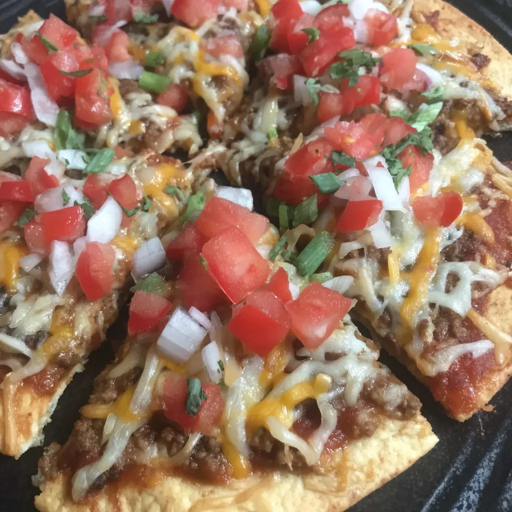 Mexican-style pizza slice topped with veggies and gooey cheese.