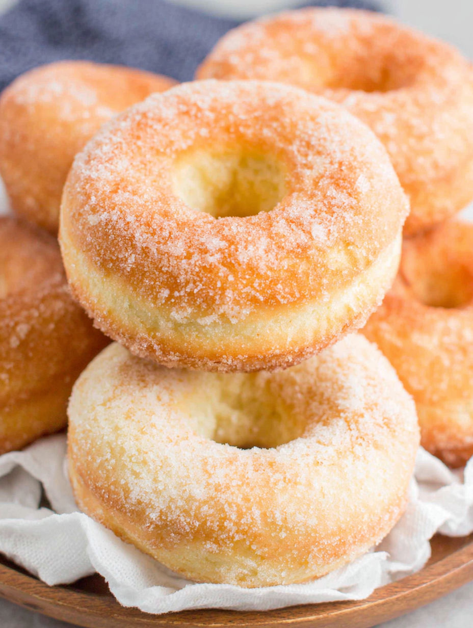 A stack of donuts with sugar on top.