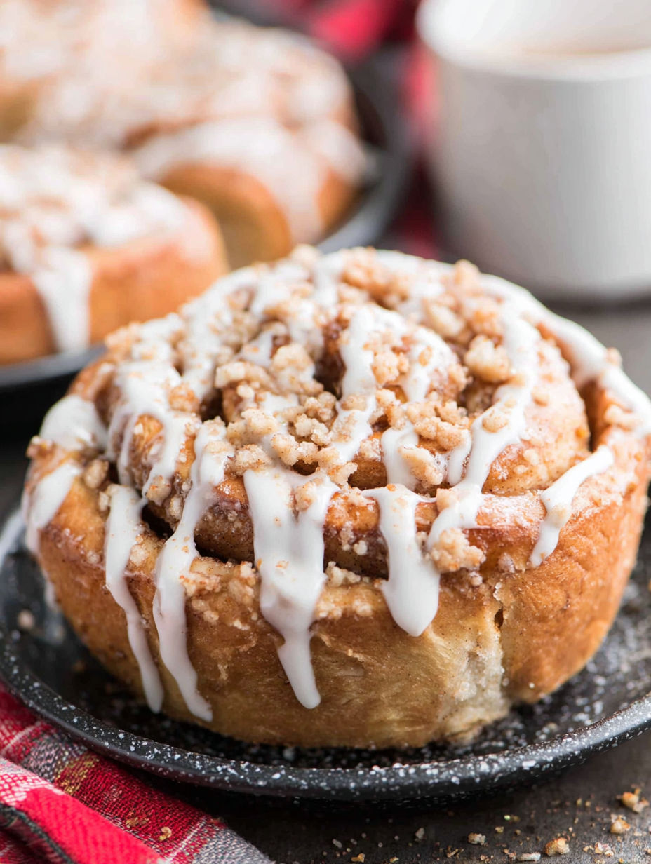 Two brown butter cinnamon rolls on a plate.