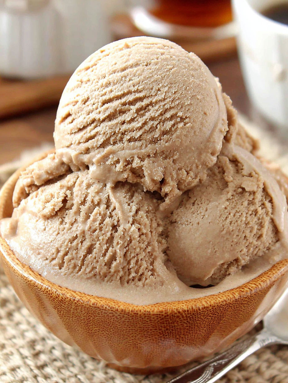 A bowl of ice cream with a scoop of vanilla ice cream.
