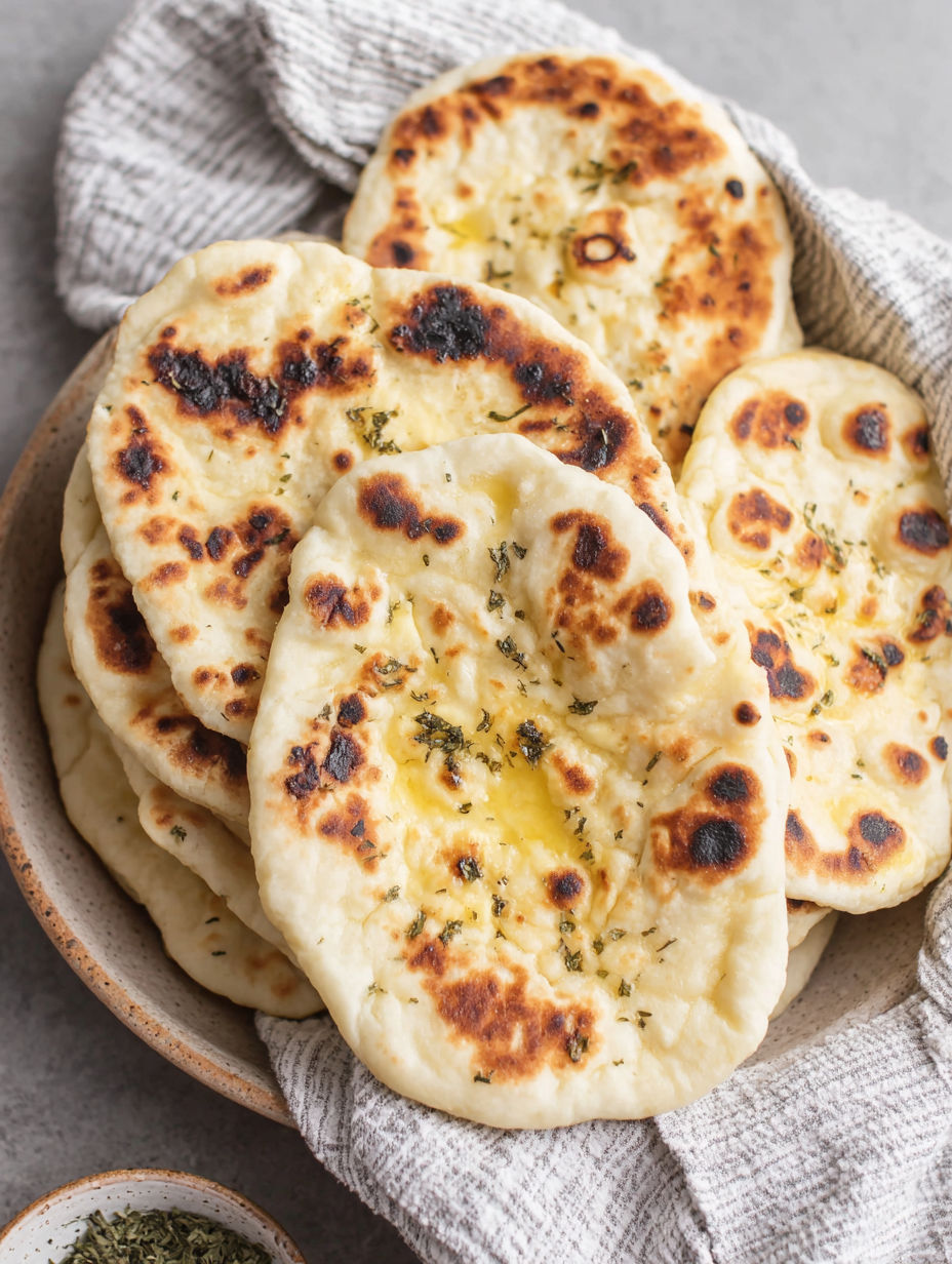 A bowl of pita bread with cheese and herbs.