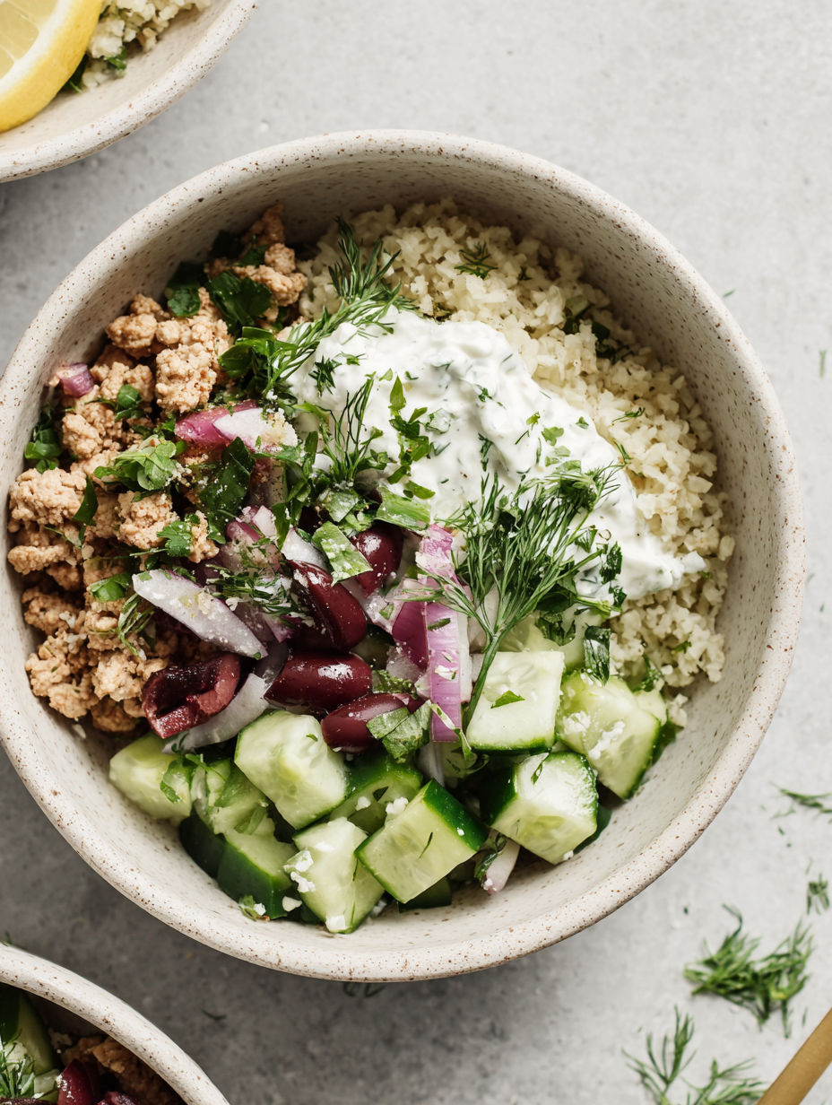 A bowl of rice, vegetables, and meat.
