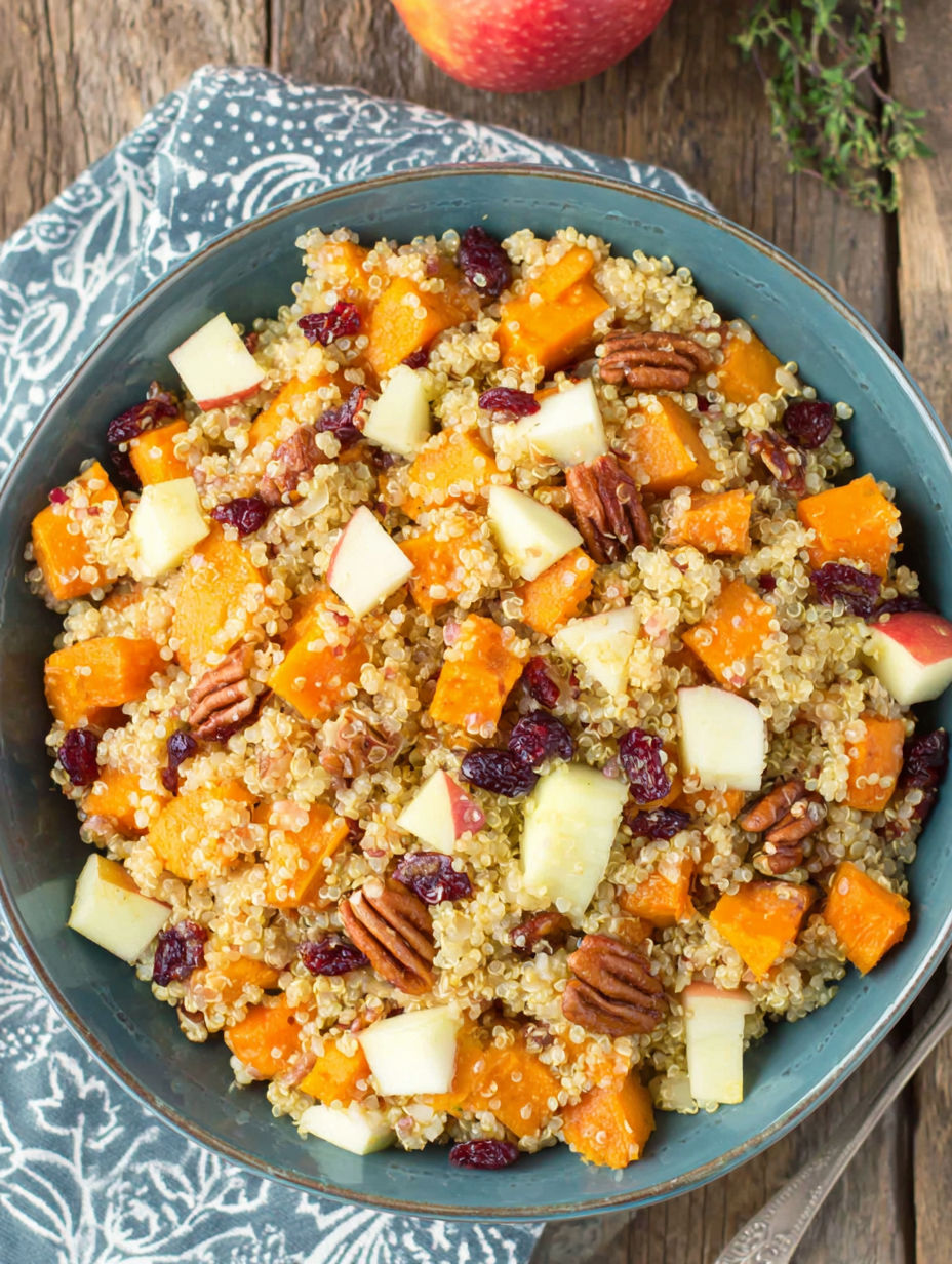 A bowl of food containing sweet potatoes, apples, and quinoa.