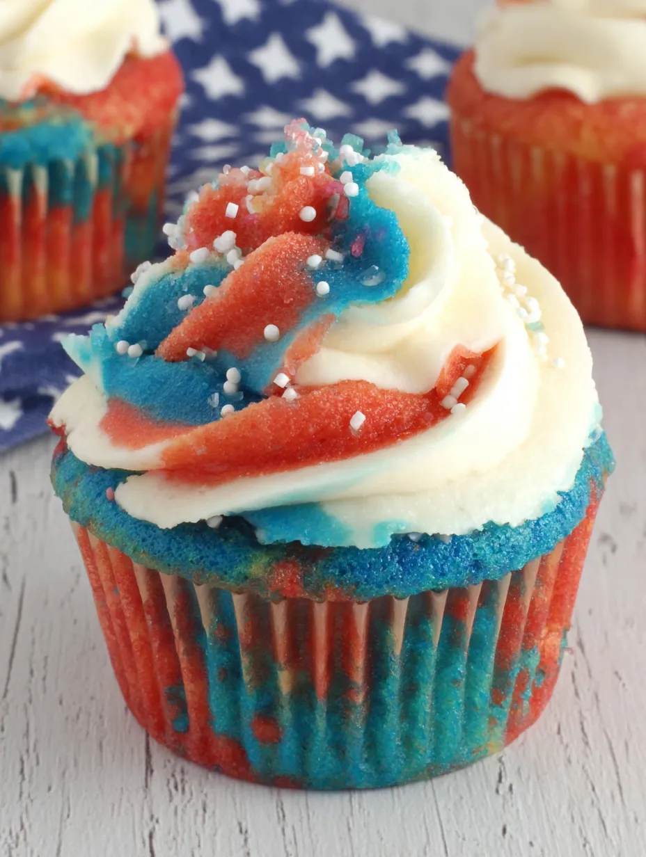 A red, white and blue cupcake with white frosting.