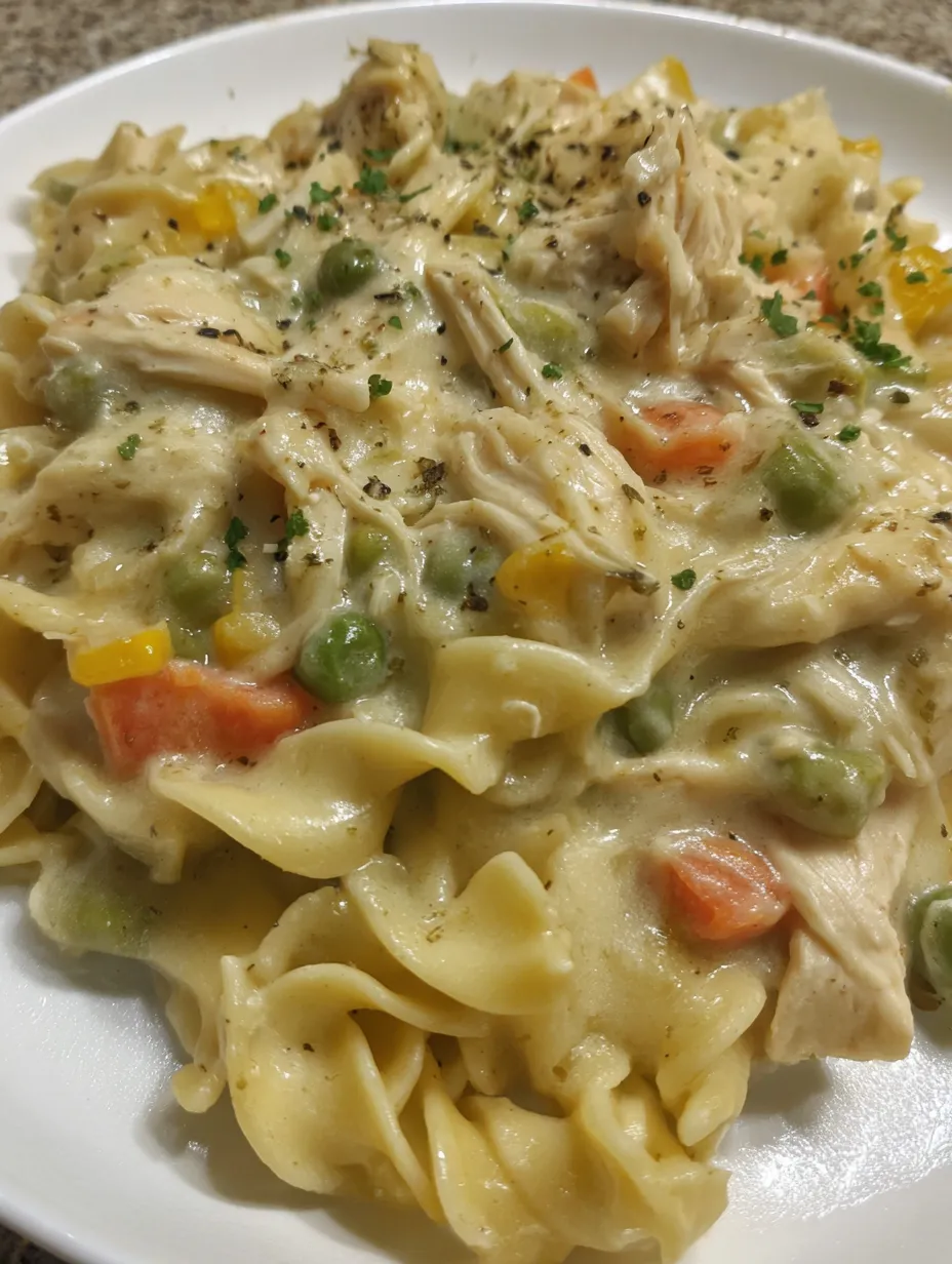 A plate of food with chicken, peas, and noodles.