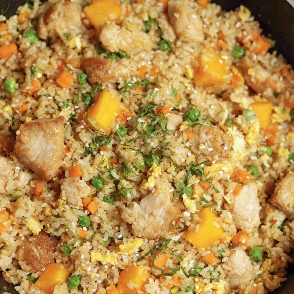 Mango chicken fried rice with peas and carrots.