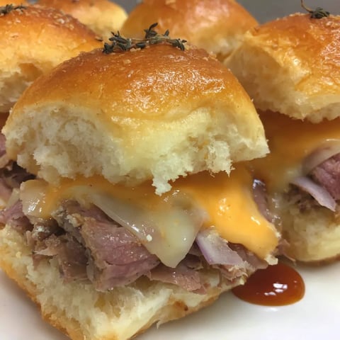 A dish of melty cheese and beef sliders.