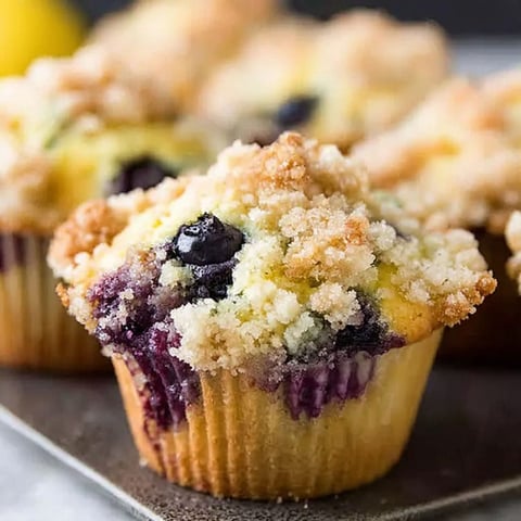 A muffin with blueberries and lemon zest.