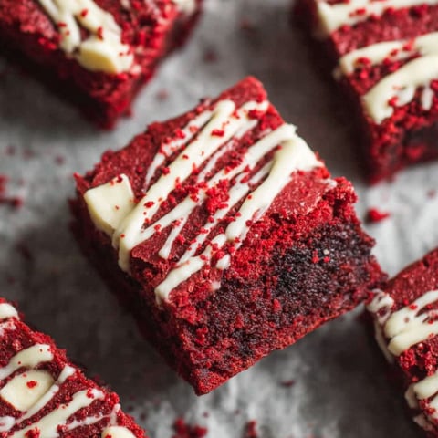 A close up of a red velvet brownie with white icing.