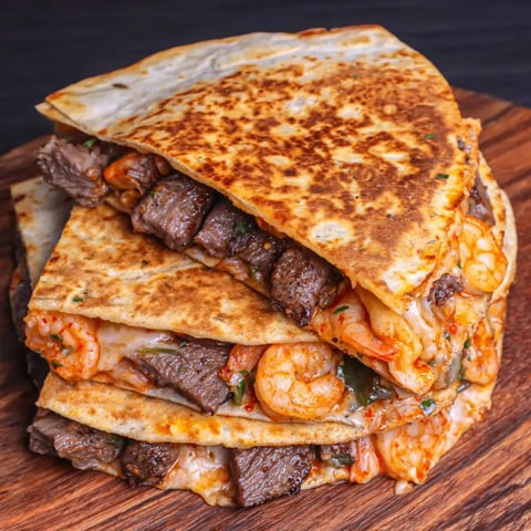 Golden toasted Creole Steak and Shrimp Wraps stacked high.