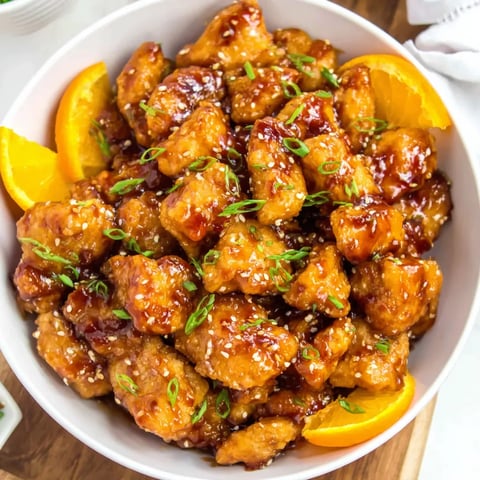 A plate of tangy orange chicken pieces.