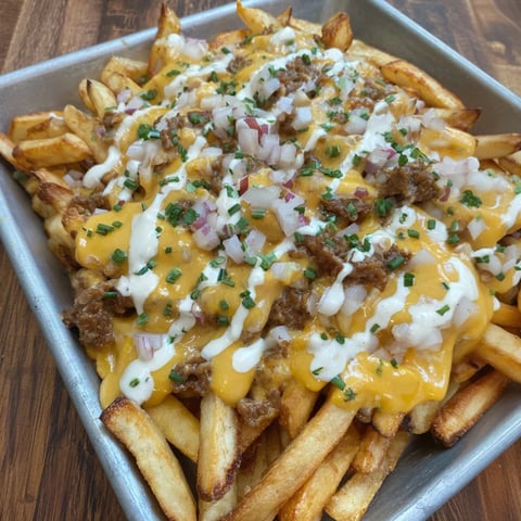 A plate of animal style fries loaded with toppings.