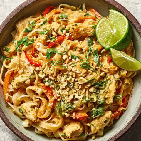 A bowl of creamy peanut-lime chicken with noodles.
