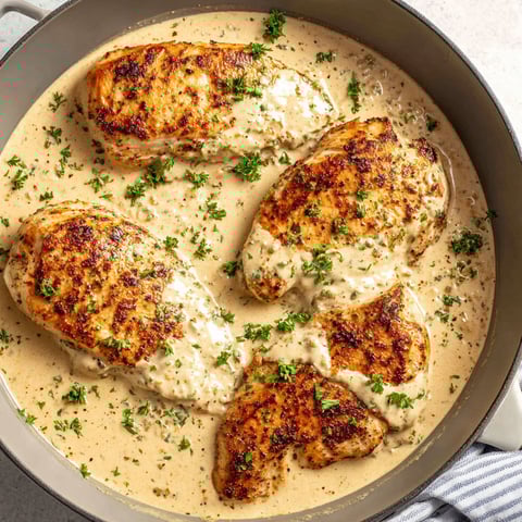 A pan of chicken covered in cream cheese sauce.