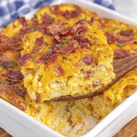 A slice of cheesy bacon casserole served on a white plate.