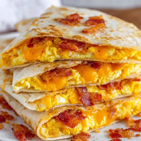 Bacon, egg, and cheese quesadillas stacked on top of each other.