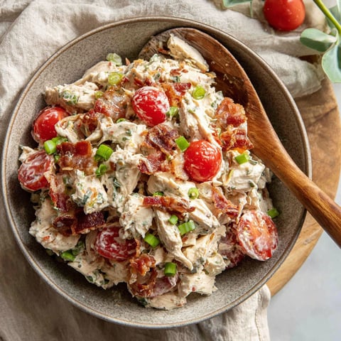 A bowl of chicken salad with BLT toppings.
