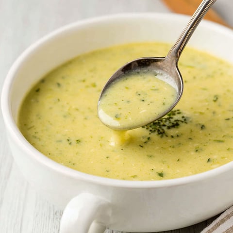 A spoon is in a bowl of soup.