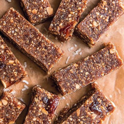A close up of a bar of nutty date bars.