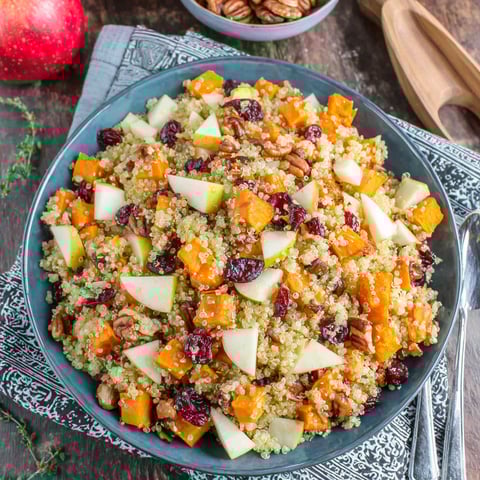A bowl of food with apples, sweet potatoes, and quinoa.