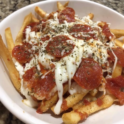 A dish piled with crispy fries, melted cheese, tangy tomato sauce, and slices of pepperoni.