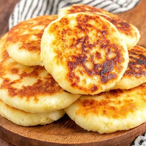 Arepas con queso on a wooden table.