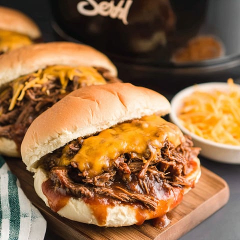 Two slow cooker beef and cheddar sandwiches.