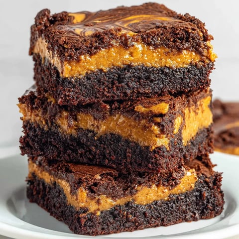 A stack of brownies with pumpkin in the middle.