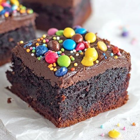 A close up of a chocolate cake with a sprinkle topping.
