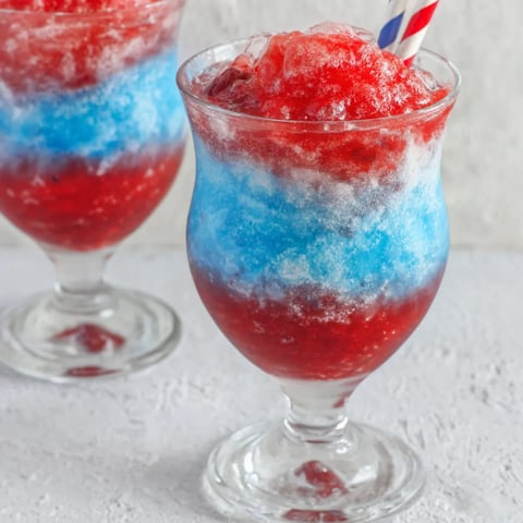 Two glasses of red, white and blue slushies.