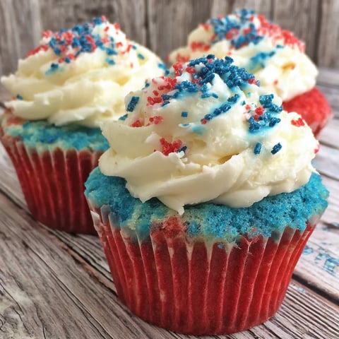 Three red white and blue cupcakes on a table.