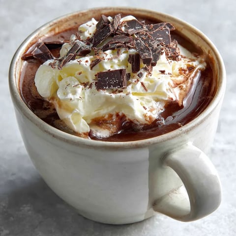 A cup of hot chocolate with whipped cream on top.