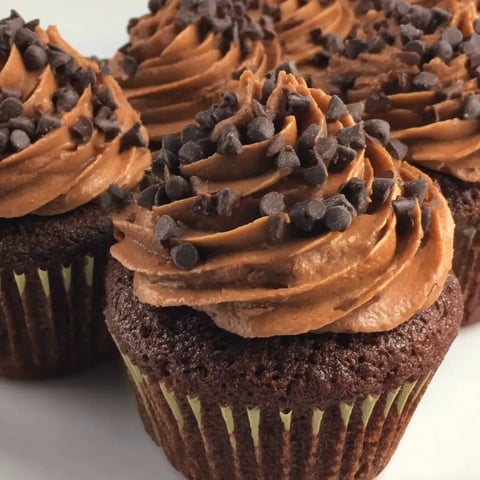 Three brown cupcakes with chocolate frosting.