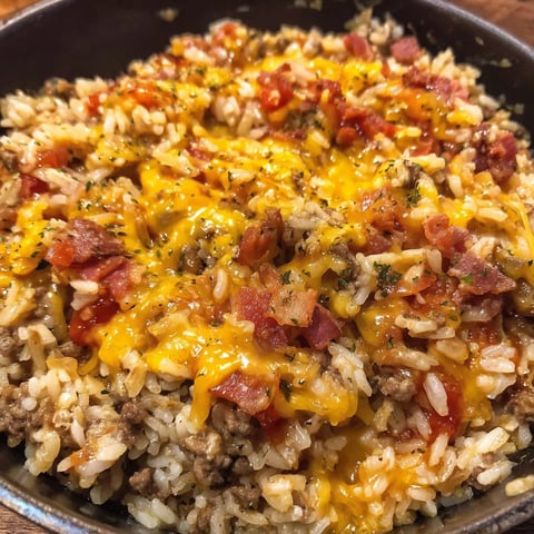 A bowl of rice with bacon and cheese.