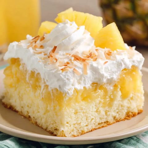 A slice of Hawaiian Poke Cake with coconut on top.