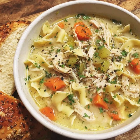 A bowl of creamy chicken noodle soup.