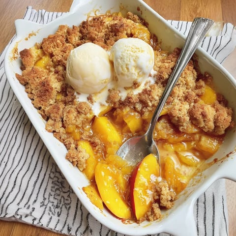 A white bowl filled with peaches and ice cream.