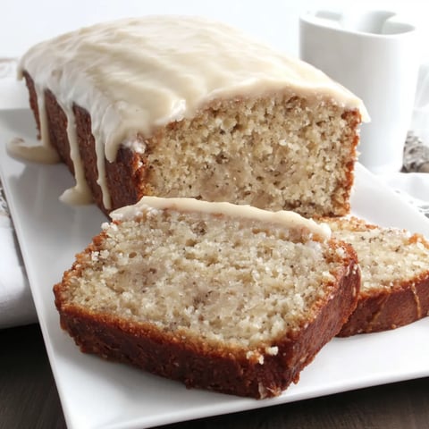 A slice of banana cake with cream cheese frosting.