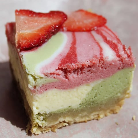 A slice of a Strawberry Matcha Latte Cheesecake Bar.