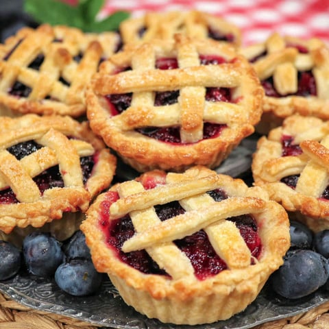 A plate of mini blueberry pies.