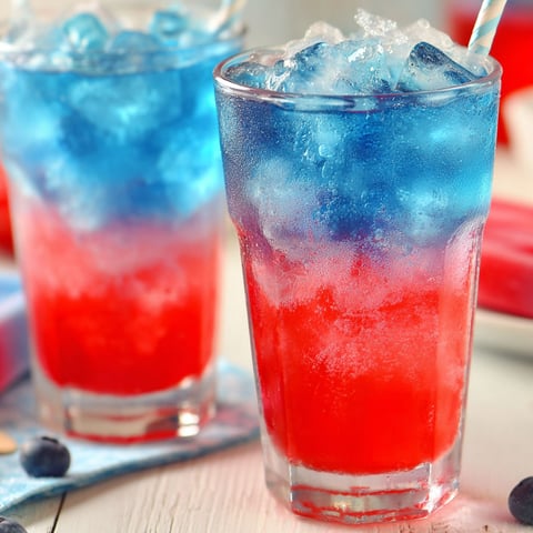 Two glasses of blue, red and white drinks.