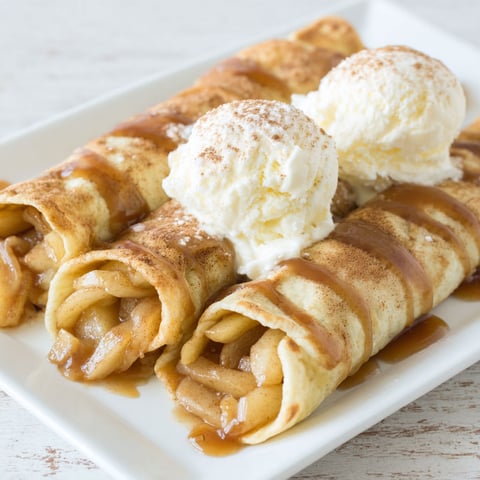 A plate of apple pie enchiladas with ice cream on top.