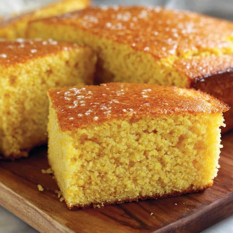 A slice of cornbread with honey butter on top.
