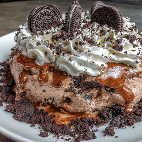 A plate of chocolate and white frosting with Oreo cookies on top.
