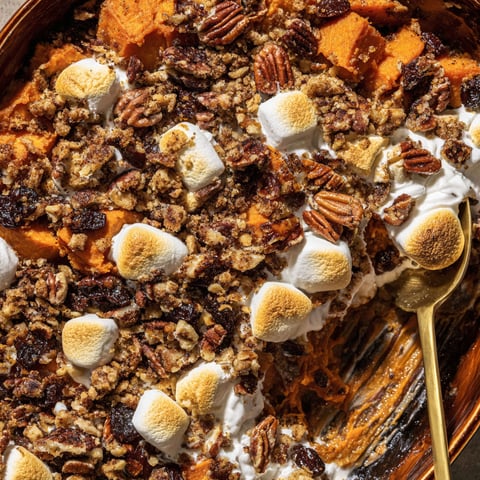 A close up of a casserole with marshmallows and pecans.