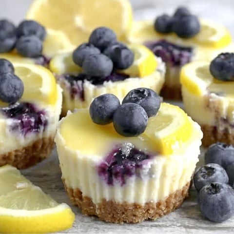 A plate of mini lemon blueberry cheesecakes.