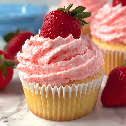 A cupcake with strawberries on top.