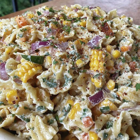 A bowl of pasta salad with corn and other vegetables.