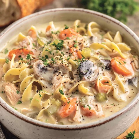 A bowl of creamy chicken noodle soup.