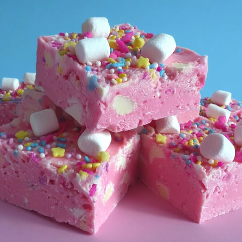 Pink cake with marshmallows and sprinkles.